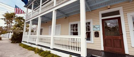 A two-story building with a porch, a brown door, and a sign for 'The Independent Inn'.