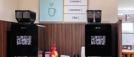 A coffee station with two coffee machines, a menu board, and various coffee-related items.