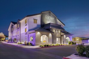 A hotel with a modern design, featuring a prominent 'Garnier' sign, multiple windows, and a well-lit entrance.