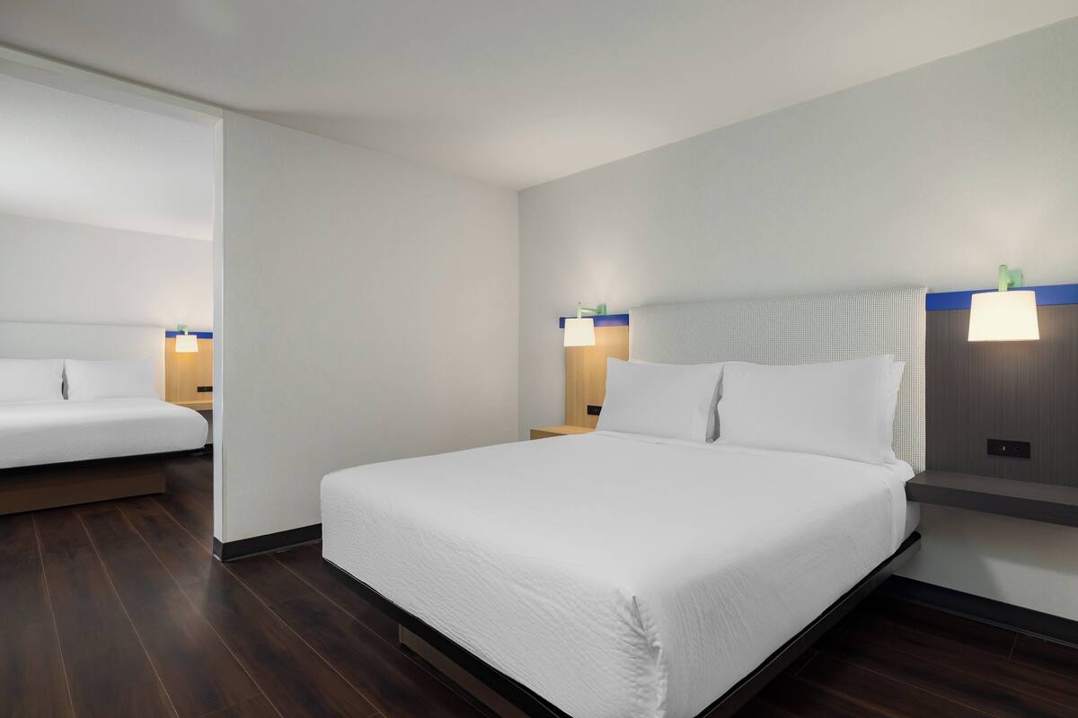 A hotel room with a large bed, two bedside tables, and a nightstand.