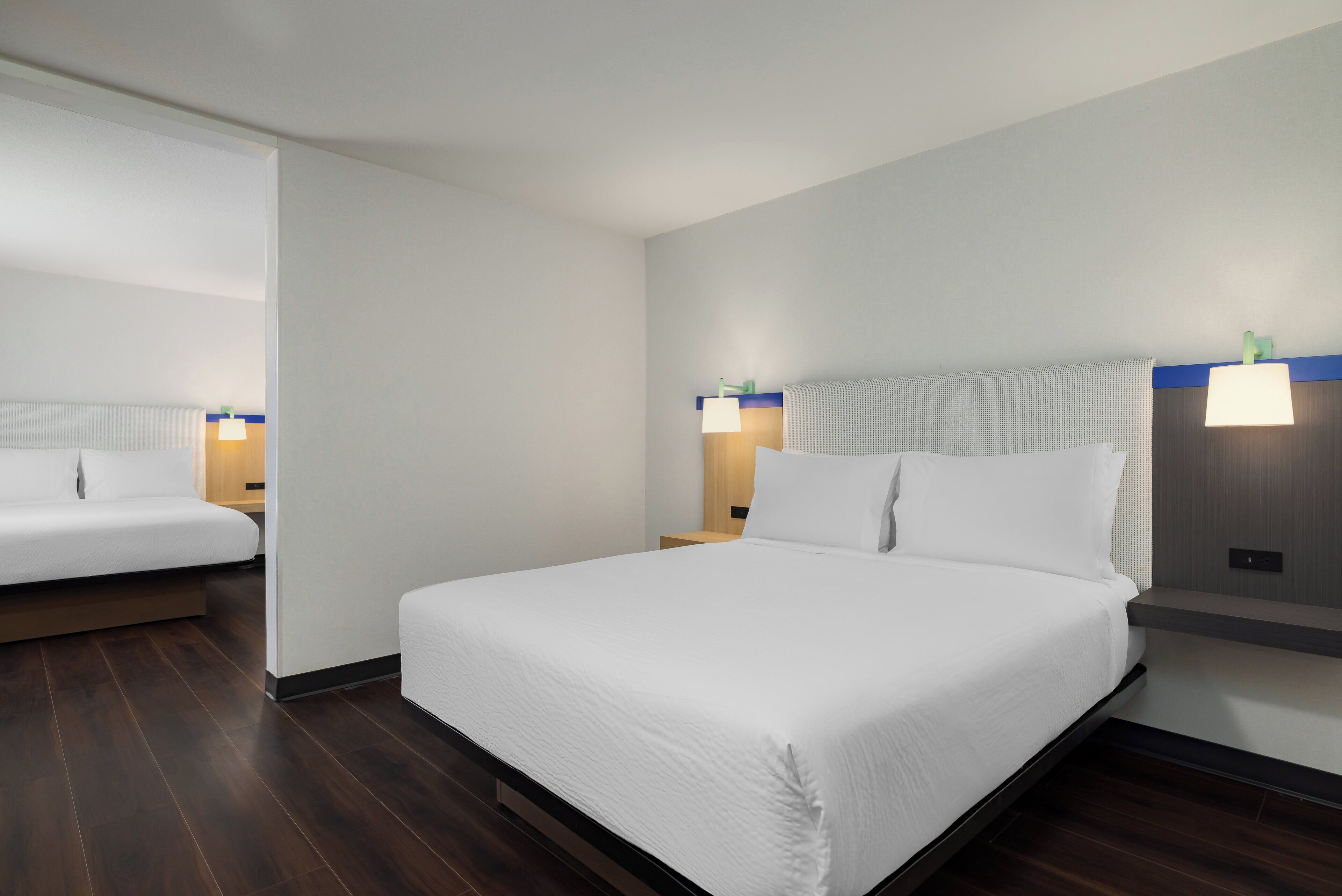 A hotel room with a large bed, two bedside tables, and a nightstand.