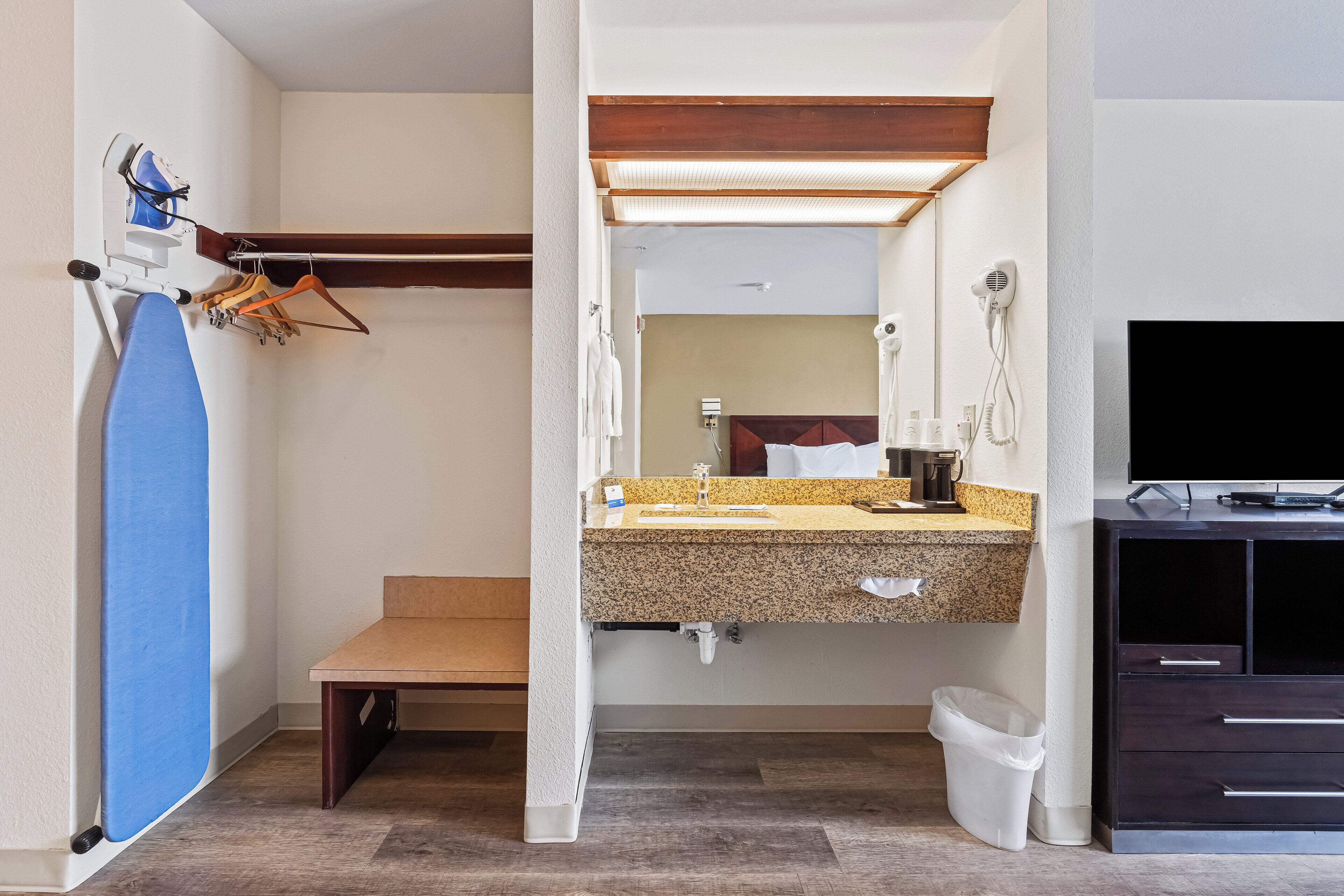 Un bagno con lavandino, specchio, asciugamano e televisore.