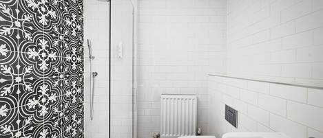 Une salle de bain avec douche, toilettes et baignoire.