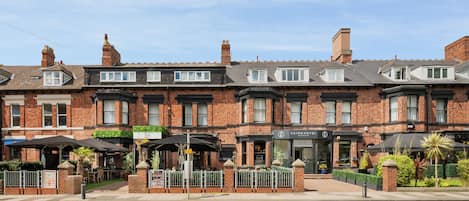 A row of terraced houses with a restaurant and a hotel.