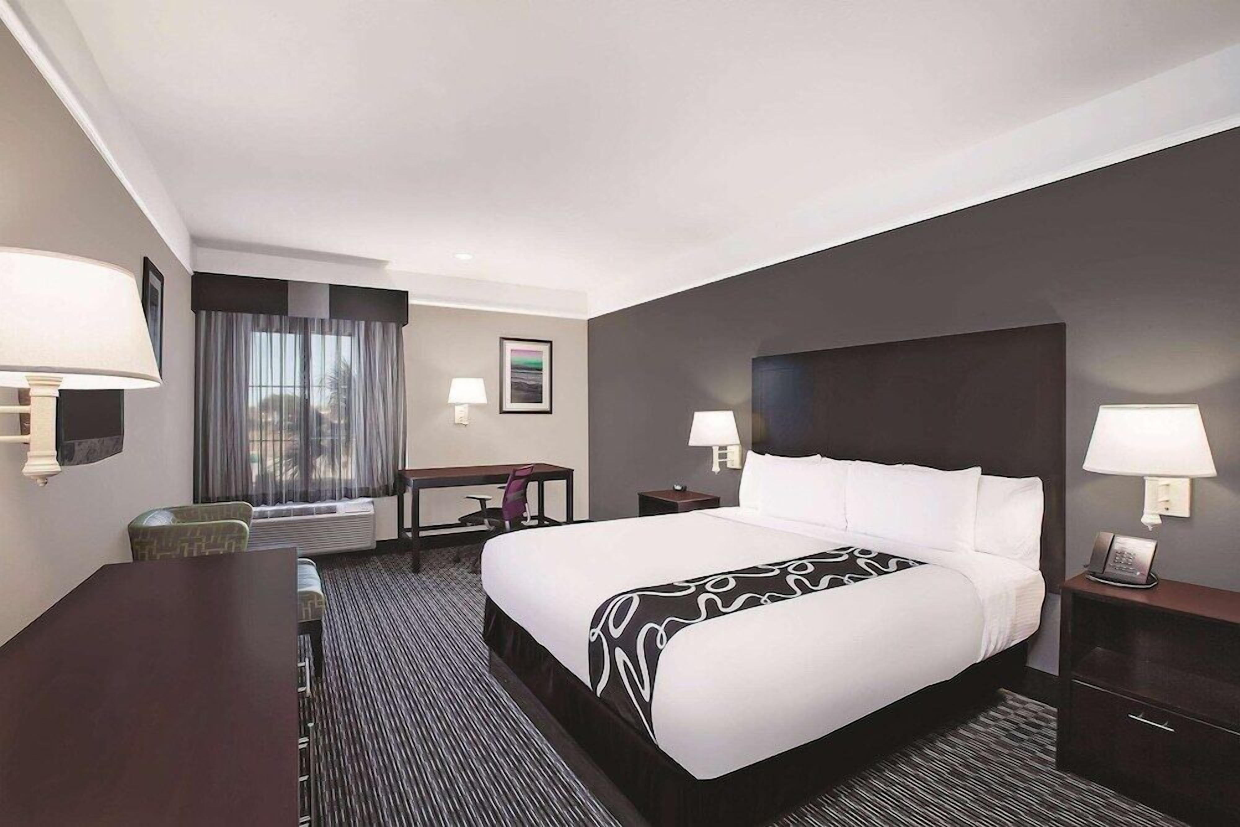 Premium bedding, desk, laptop workspace, blackout drapes