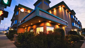 A hotel with a modern design, featuring a prominent entrance with a covered area and multiple windows. - Hotel Aluxor SFO (San Bruno)