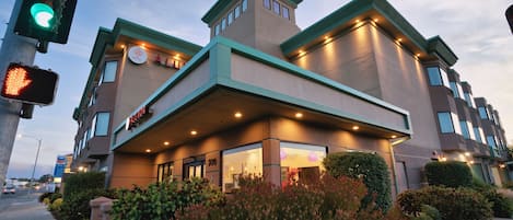 A hotel with a modern architectural design, featuring a prominent entrance with a covered area and multiple windows.