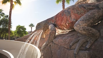 Una gran escultura de piedra con forma de lagarto, de la cual sale agua por la boca.