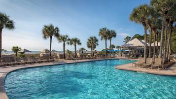 A pool area with lounge chairs and palm trees.