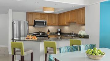 Una cocina moderna con armarios de madera, electrodomésticos de acero inoxidable y una isla central con asientos.