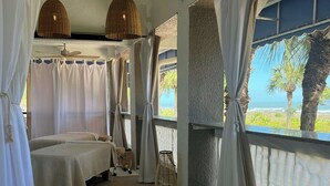 A room with two beds, a ceiling fan, and large windows with a view of the beach. - Marriott's Grande Ocean (Hilton Head Island)