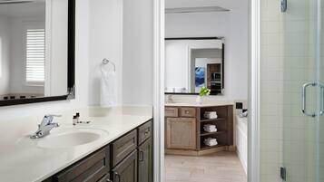 Un baño moderno con un espejo grande, dos lavamanos y una zona de ducha.