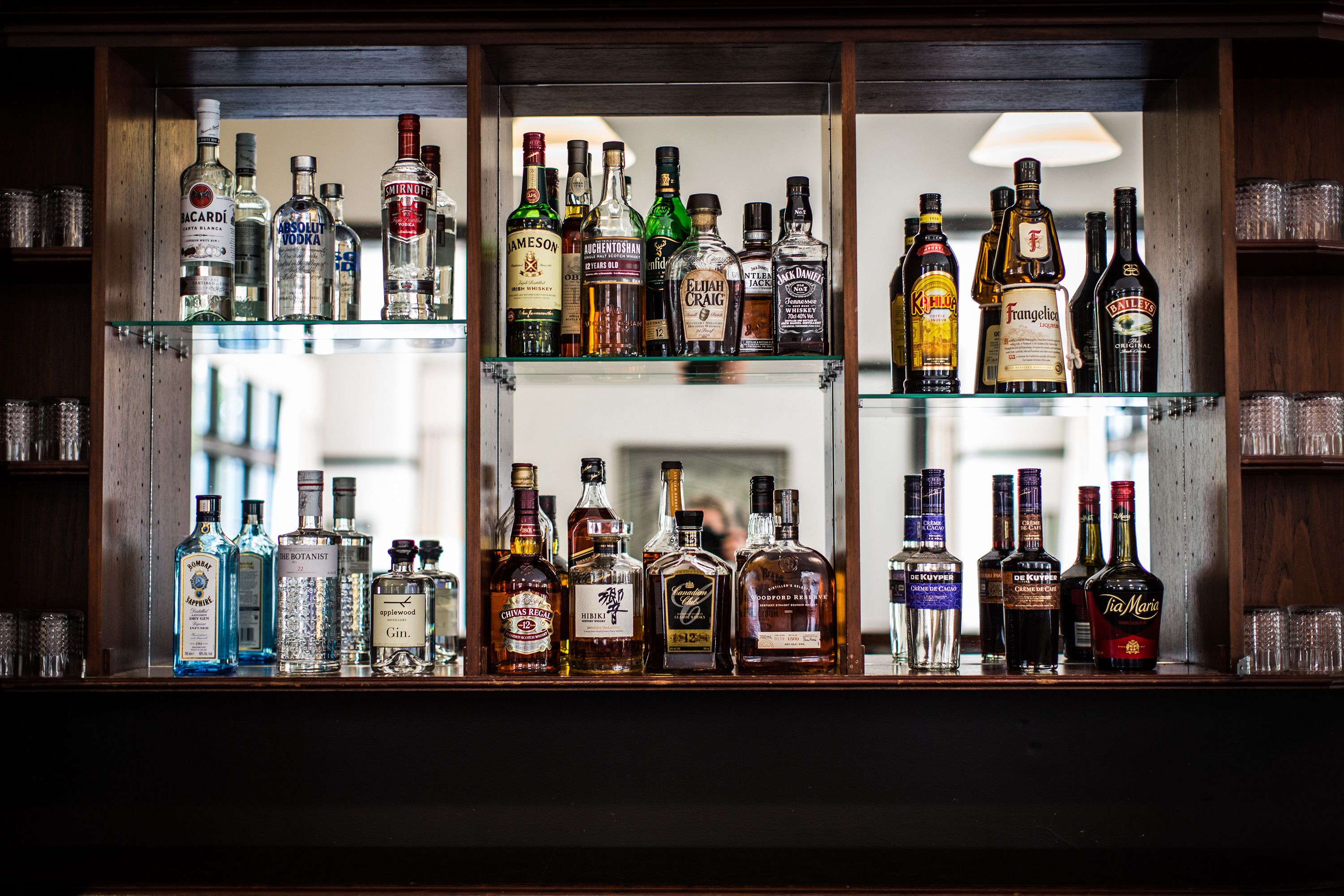 Eine Bar mit mehreren Regalen voller Spirituosenflaschen.