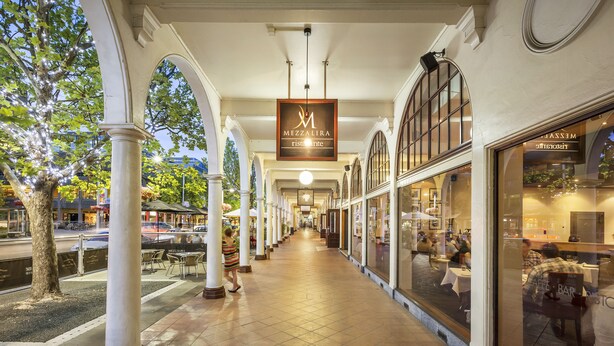 A corridor with a restaurant named "Mezzalira Ristorante" on the right, featuring large windows and a tiled floor.