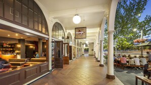 An indoor public space with seating areas, a bar, and a hanging sign.