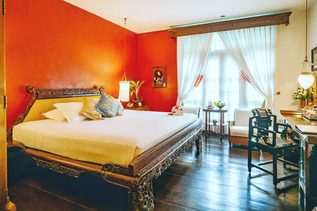 Ein Hotelzimmer mit einem großen Bett, einem kleinen Tisch mit einer Lampe und einem Sessel.