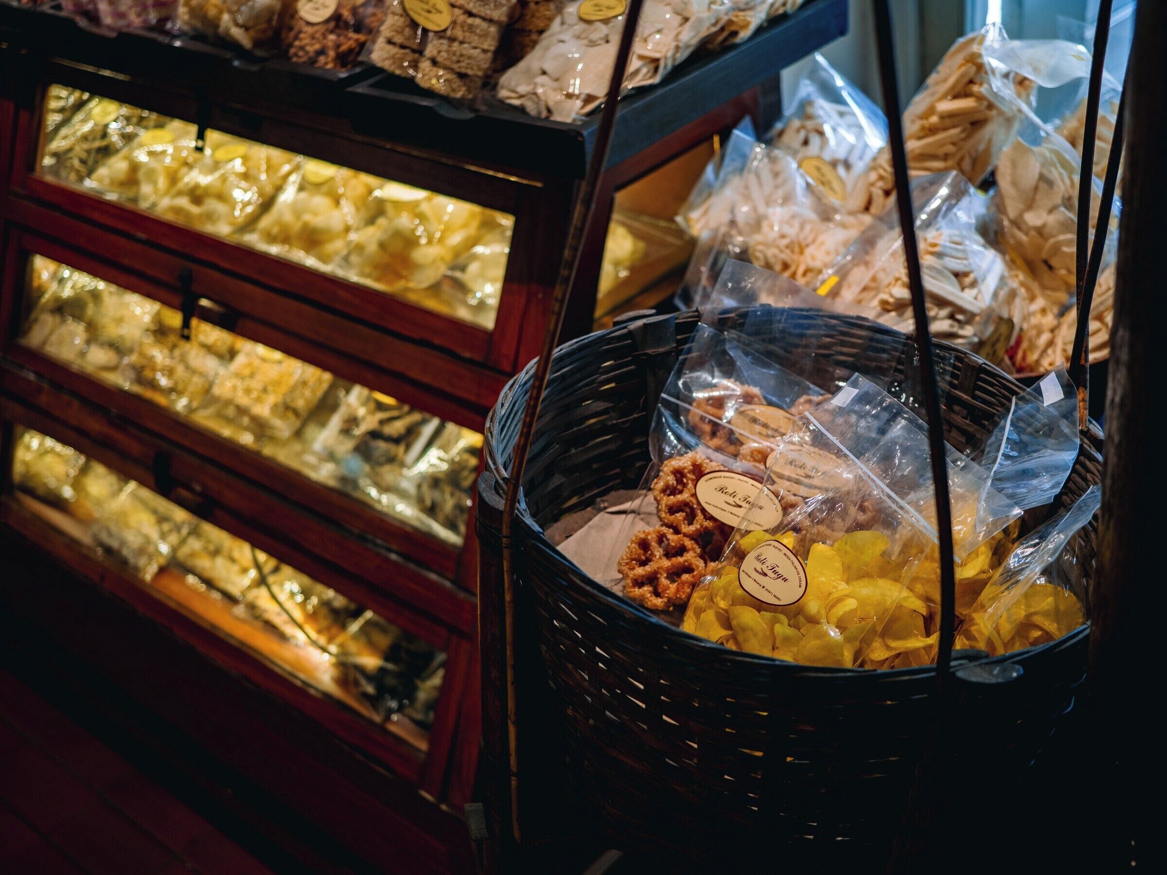 Una vitrina de pastelería con diversos productos horneados en cestas y expositores de vidrio.