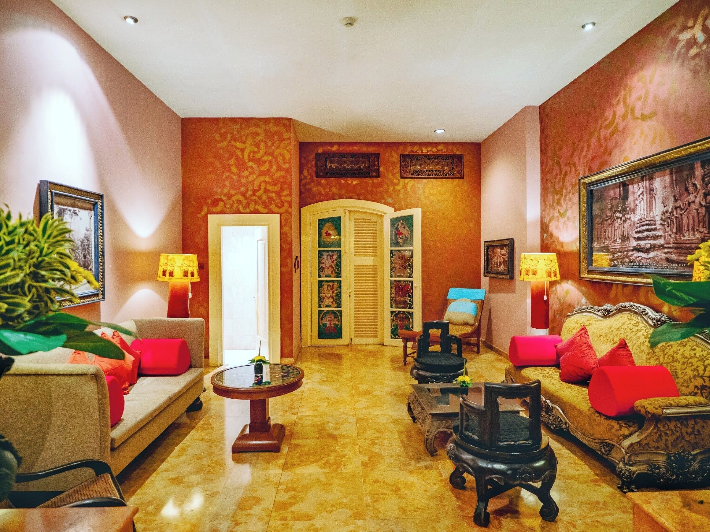 A spacious lobby with a sofa, armchairs, a small table, and a decorative cabinet.