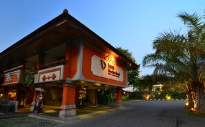 A traditional building with a sign reading "Inna Singha Beach Hotel, Resort & Spa".