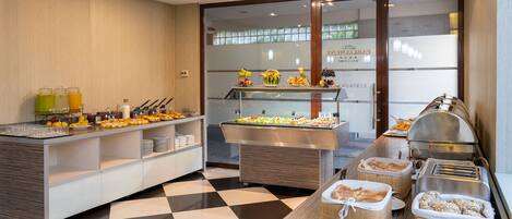 A buffet area with various food items and beverages, a checkered floor, and a glass display case.