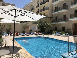 Piscine extérieure, parasols de plage, chaises longues
