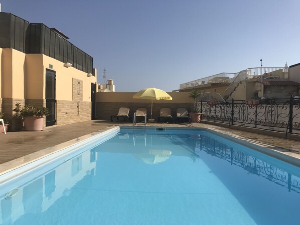 Outdoor pool, open 9:30 AM to 6:30 PM, pool umbrellas, pool loungers