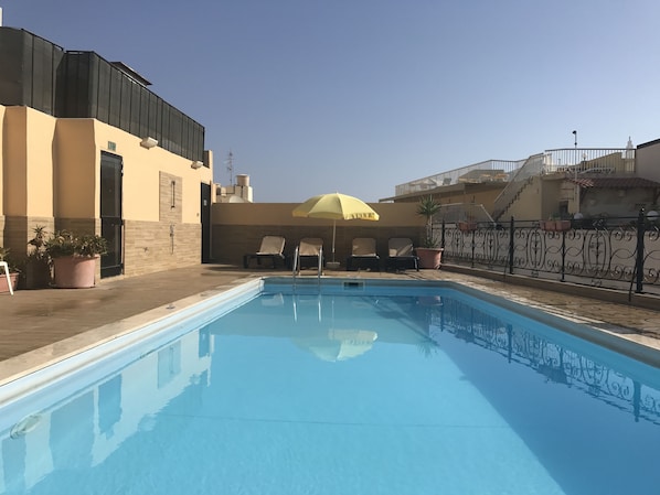 Outdoor pool, open 9:30 AM to 6:30 PM, pool umbrellas, pool loungers