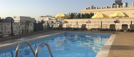 Piscine extérieure, parasols de plage, chaises longues