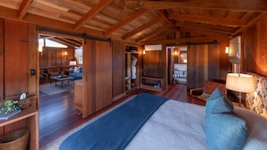 A spacious room with a large bed, a wooden ceiling, and a view of a dining area. - Spicers Hidden Vale (Grandchester)