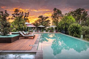 A pool area with lounge chairs, a hot tub, and umbrellas. - Spicers Hidden Vale (Grandchester)