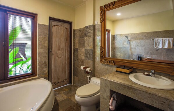 A bathroom with a bathtub, toilet, and two sinks.
