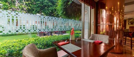 Comedor con una mesa, sillas y vista a un jardín.