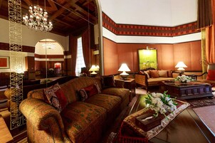 A spacious living room with a large sofa, a coffee table with flowers, and a painting on the wall.