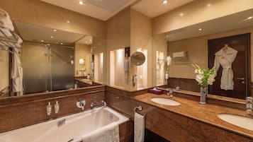 Un baño moderno con un espejo grande, dos lavabos, una bañera y una ducha.