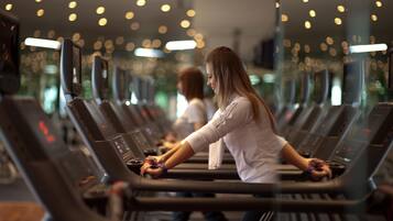 A gym with treadmills lined up in rows.