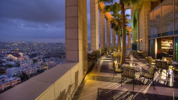 A rooftop bar with outdoor seating and a view of the cityscape. - Le Royal Hotel Amman (Amman)