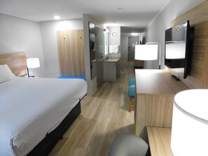 A hotel room with a bed, a desk, a chair, a TV, and a bathroom. - Days Inn by Wyndham Effingham (Effingham)