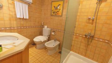 Un baño con bañera, inodoro, bidé y ducha.