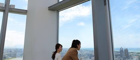A high-rise building with large windows offering a city view.