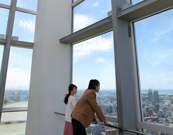 A high-rise building with large windows offering a city view. - Hotel Nikko Niigata (Niigata)