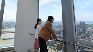 A high-rise building with large windows offering a city view. - Hotel Nikko Niigata (Niigata)