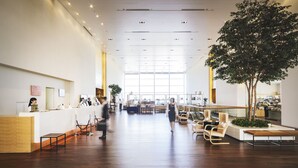 A spacious lobby with a reception desk, seating area, and a large tree. - Hotel Nikko Niigata (Niigata)