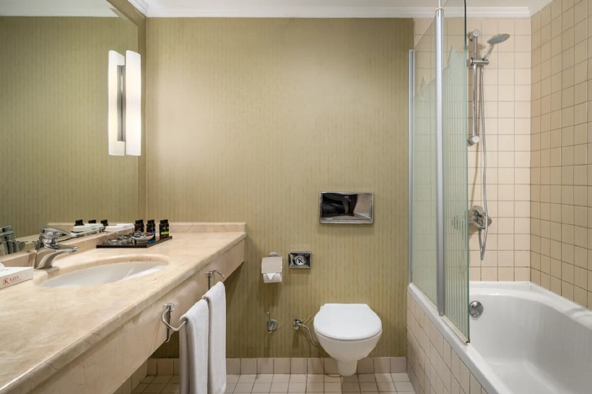 Une salle de bain avec deux lavabos, des toilettes, une douche et un miroir.