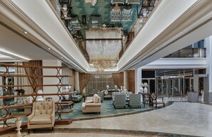 Experience the grandeur of our lobby, featuring a stunning chandelier and spacious seating areas with comfortable sofas and armchairs.