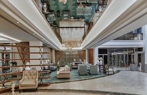 Experience the grandeur of our lobby, featuring a stunning chandelier and spacious seating areas with comfortable sofas and armchairs.