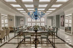 Relax in our elegantly designed lobby, featuring a grand chandelier, comfortable seating, and large windows.