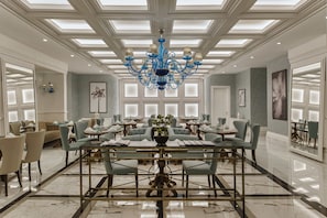 Relax in our elegantly designed lobby, featuring a grand chandelier, comfortable seating, and large windows.