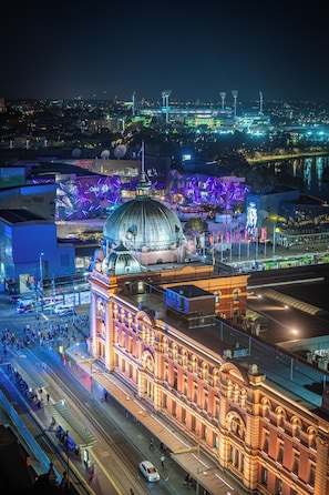 A historic building with a large dome and classical architecture, located near a busy street with modern lighting.