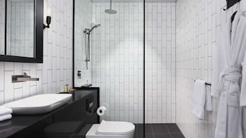 A modern bathroom with a white sink, mirror, and toilet, a shower area, and a towel rack with a robe.