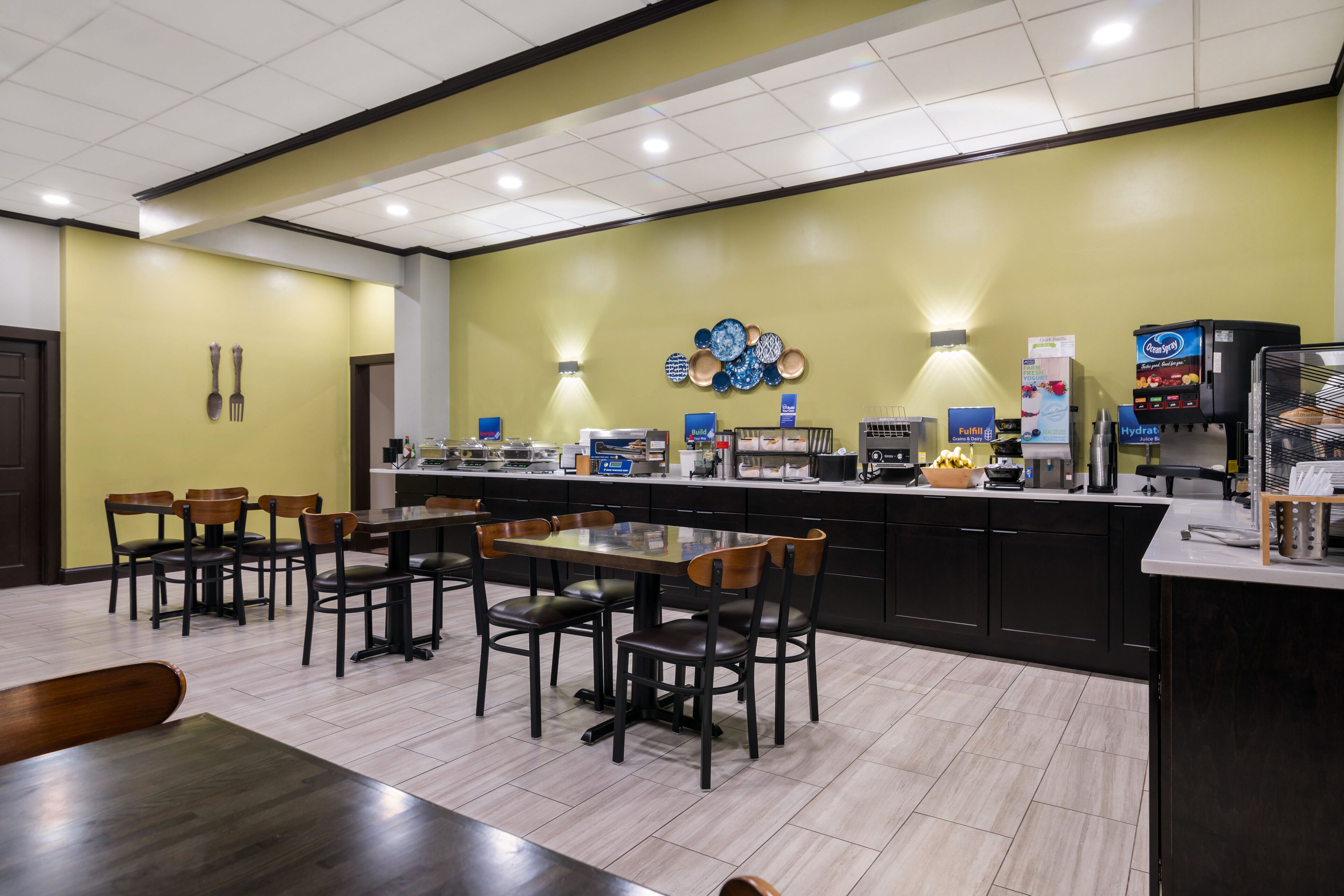 A restaurant with a counter, seating area, and various food service equipment.